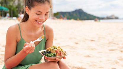 Poke - fish salad from Hawaii / a woman eats a poke